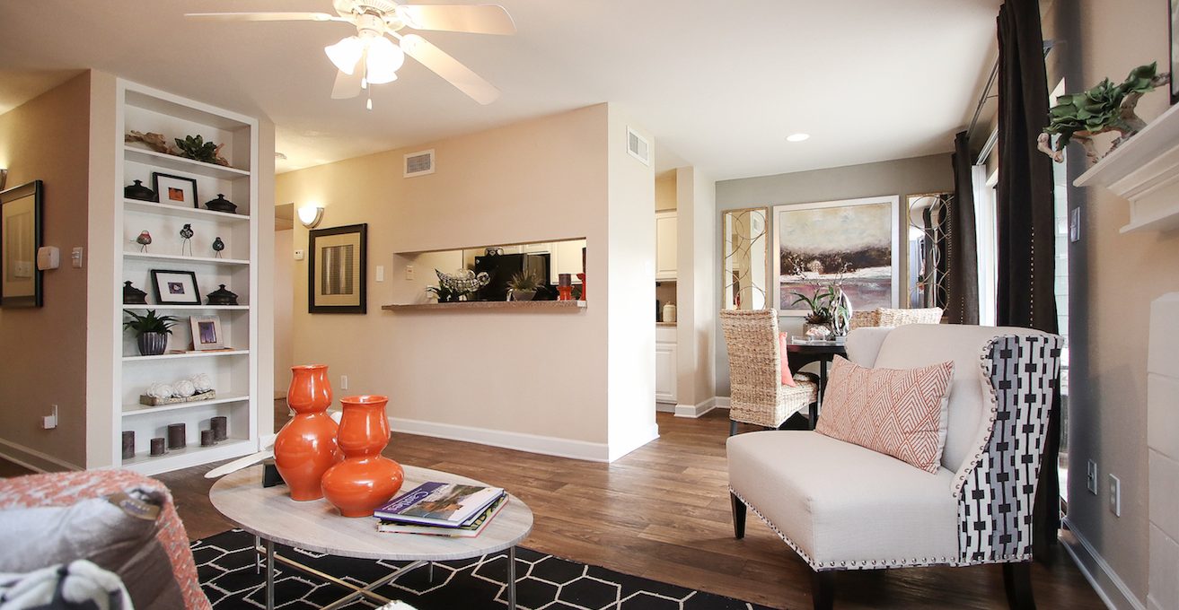 a living room with a white couch and orange chairs at The Westmount at London Park